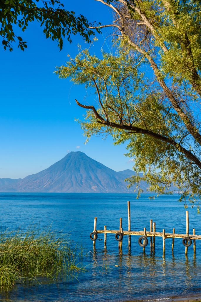 Wooden pier at Lake Atitlan on the shore at Panajachel, Guatemala. With beautiful landscape scenery of volcanoes Toliman, Atitlan and San Pedro in the background.