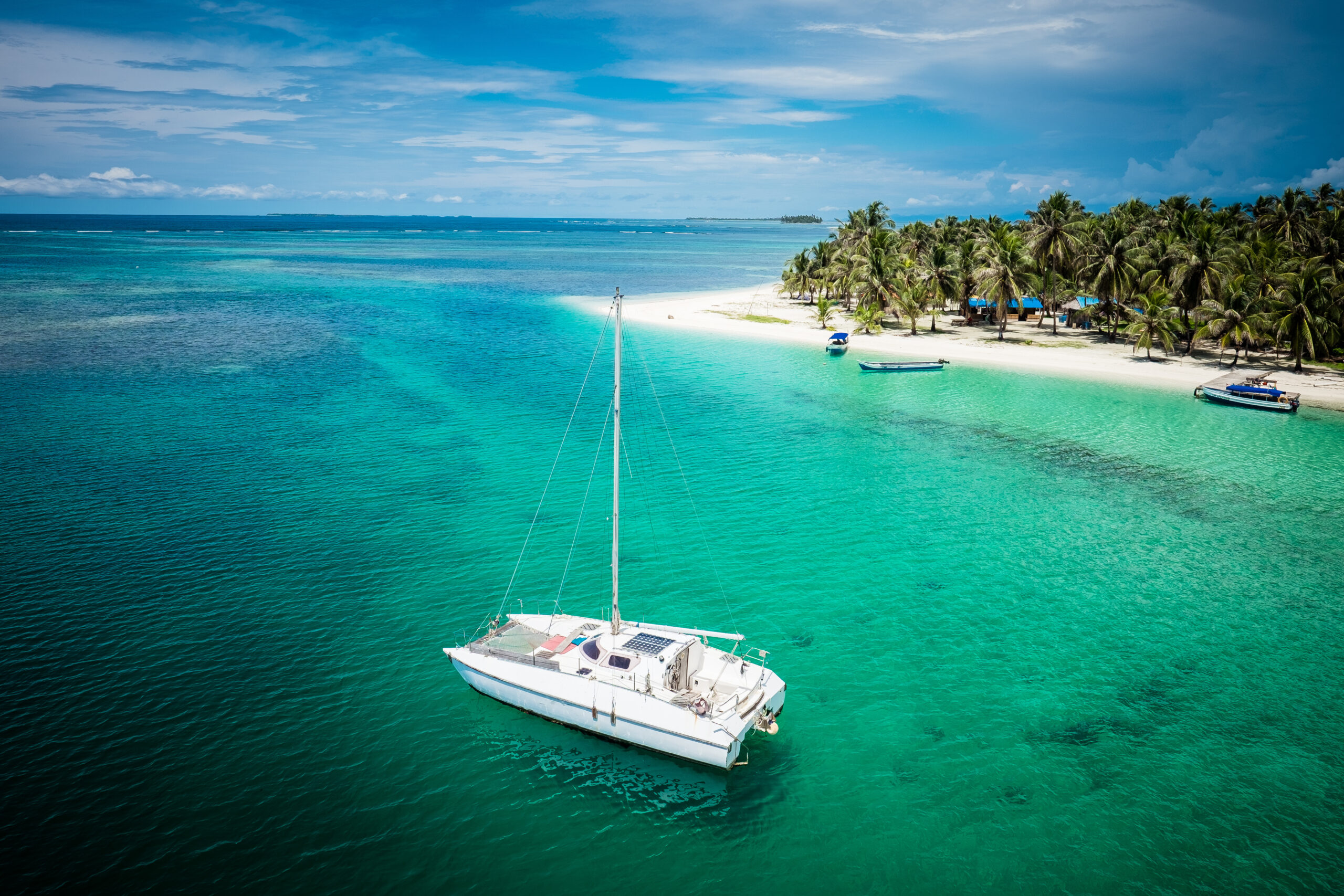 Sail boats docked by beautiful islands